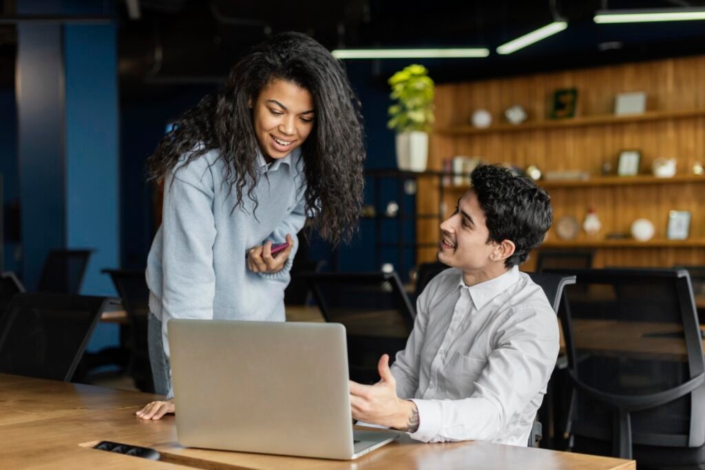 coworkers working together office with laptop